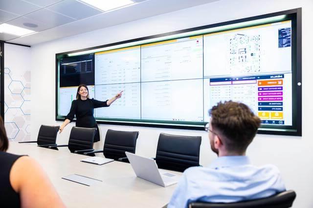 Professional woman pointing at a presentation screen in a boardroom